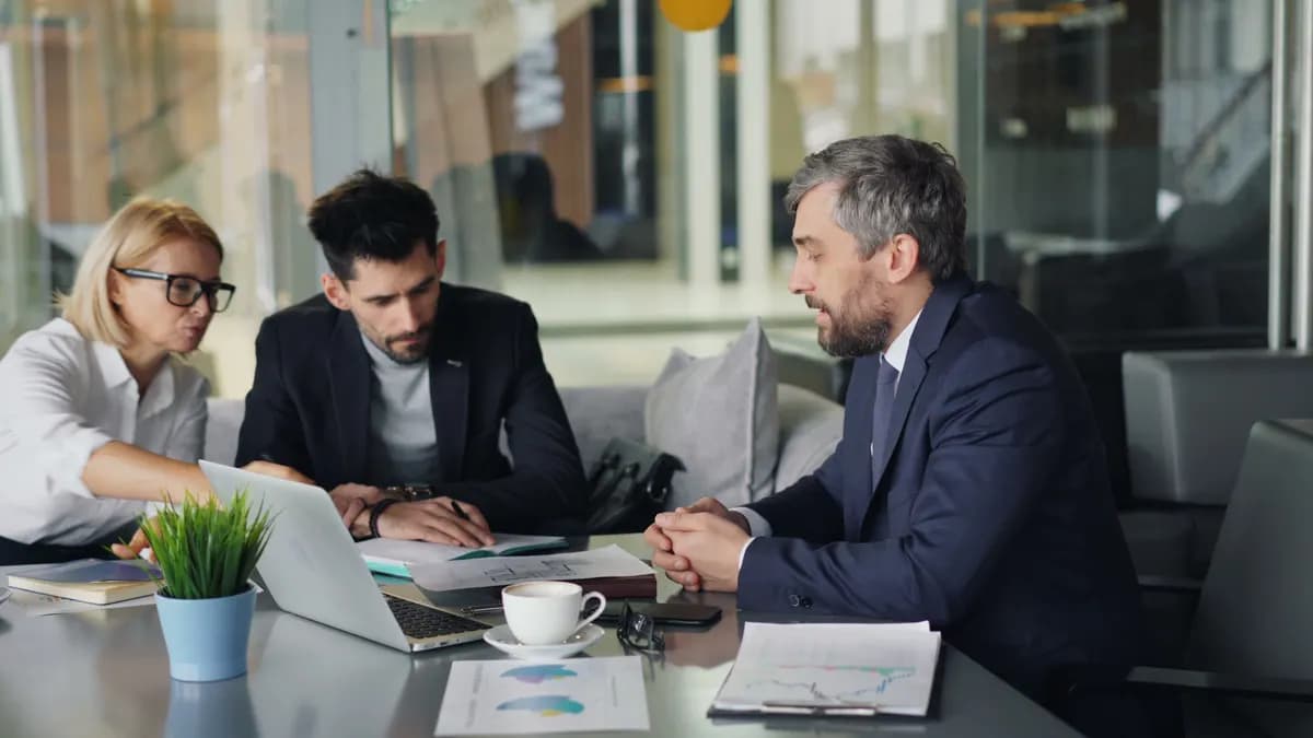 Dos consultores revisando gráficos y reportes en un escritorio